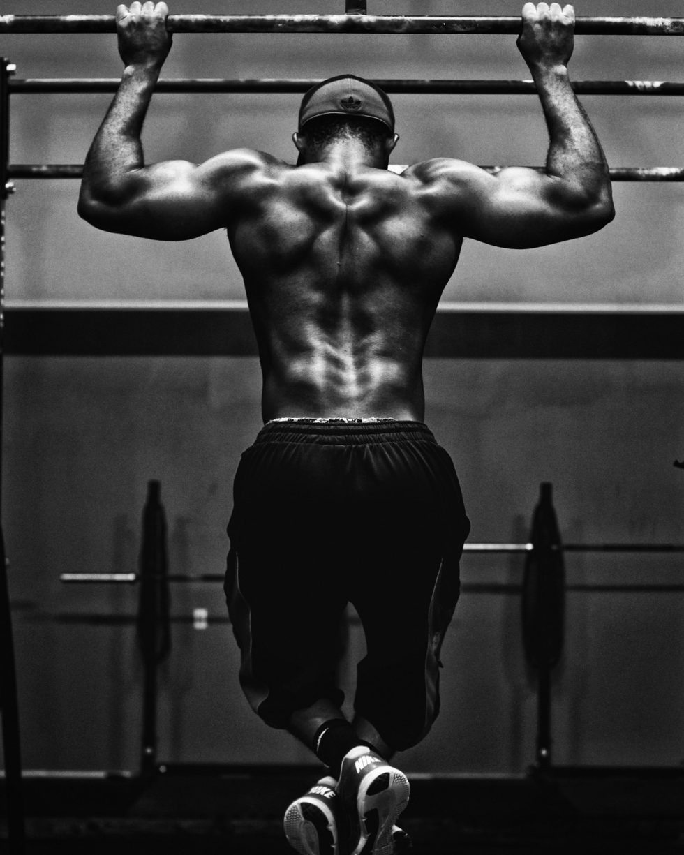 A man performing a pull-up, black and white